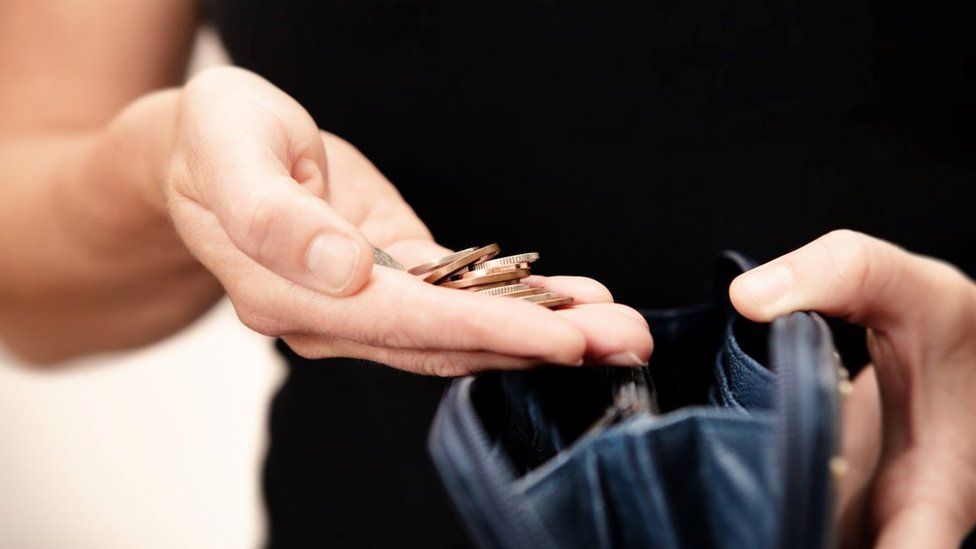 Close up hands with purse and coins