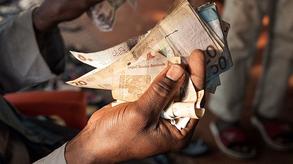 Someone holding Sudanese money