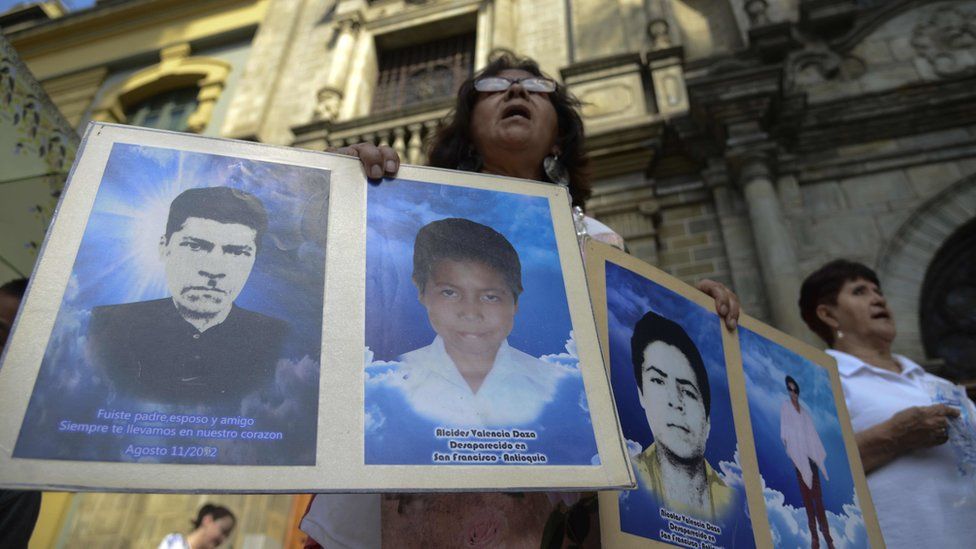 A protestor holds portraits of disappeared relatives in Medellin