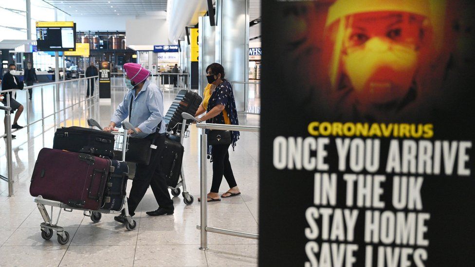 Passengers wear masks as they arrive at Heathrow Airport, in Britain