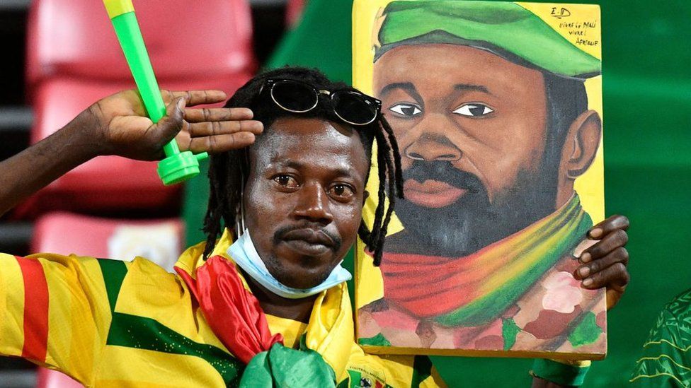 A Mali supporter holds a portrait of Malian junta leader Colonel Assimi Goita before the Africa Cup of Nations (CAN) 2021 round of 16 football match between Mali and Equatorial Guinea at Limbe Omnisport Stadium in Limbe on January 26, 2022