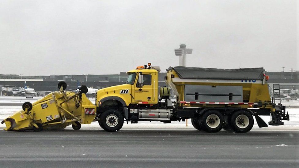 Gritters clear the runway at John F Kennedy airport