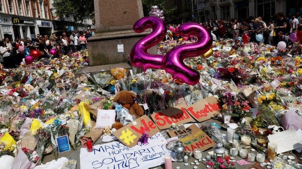 Balloons, flowers and messages of condolence are left for the victims