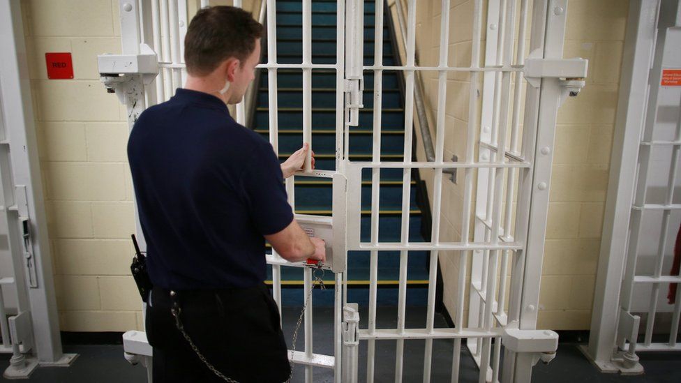 Prison officer locking a gate