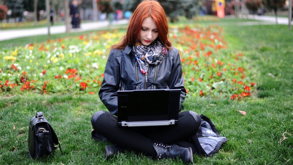 woman using laptop in park