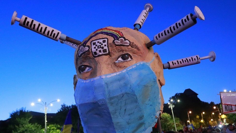 Romanian anti-vaccine activists display a huge metaphoric human head with syringes on 2 October 2021