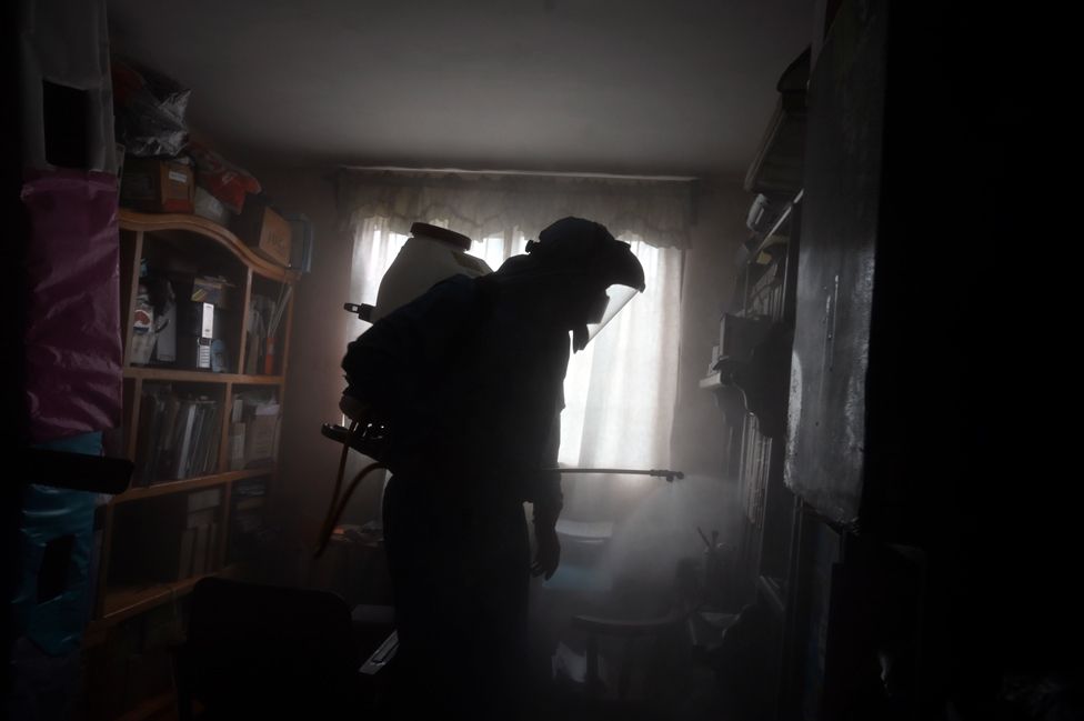 A local government worker disinfects a house in Mexico City, Mexico