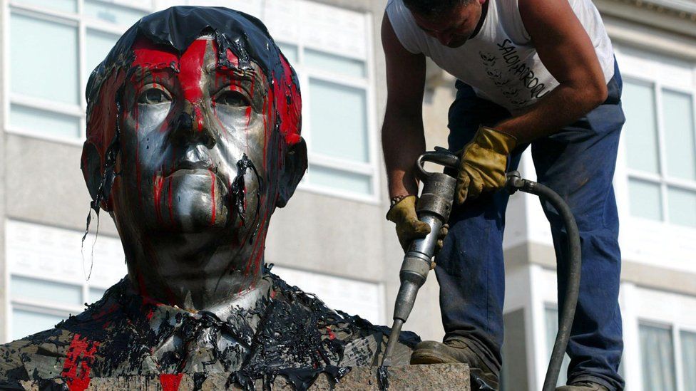 A worker frees with a drill a bust of Spanish dictator Francisco Franco (1892-1975) from its plinth prior its removal in the central square of the Spanish northwestern village of Ponteareas, 08 July 2003 following a decision by the village council.
