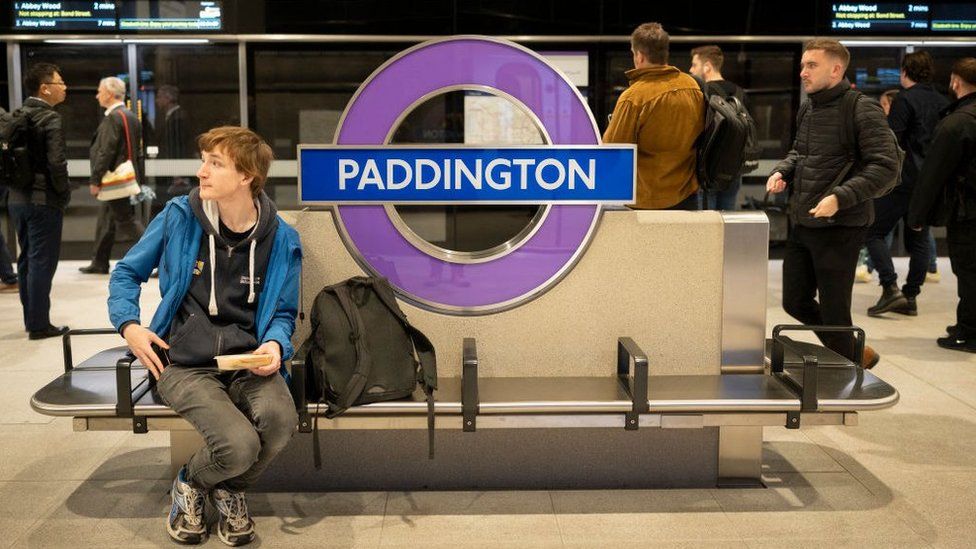 A man sits on the Elizabeth line platform a Paddington