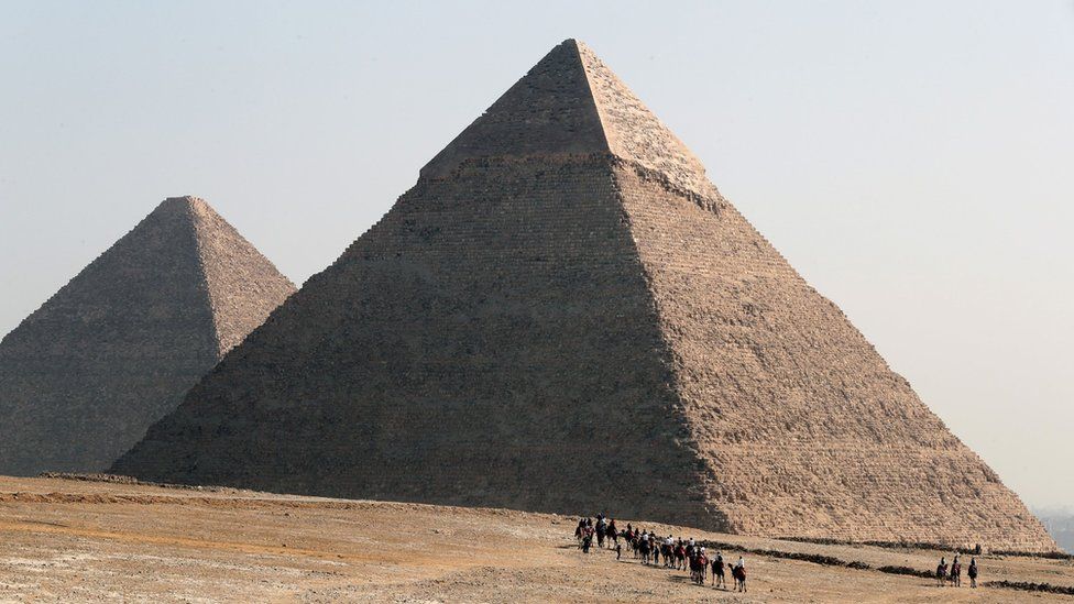 Tourists visit the pyramids on the Giza plateau, Egypt (2 February 2023)