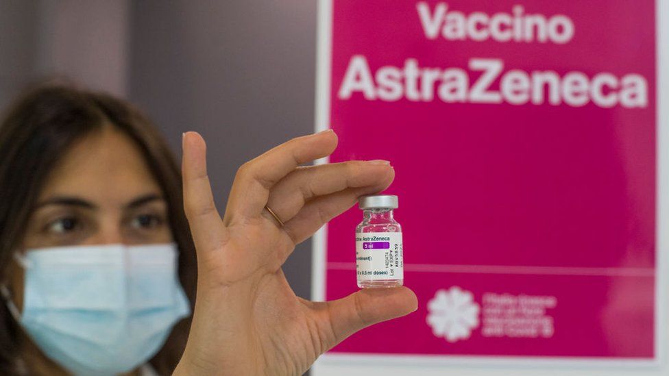 A medical worker in Italy holding an AstraZeneca vaccine vial