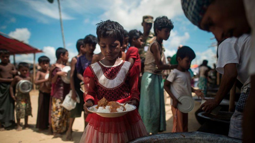 На этом снимке, сделанном 1 октября 2017 года, мусульманские беженцы-рохинджа выстраиваются в очередь за едой в пункте раздачи в лагере беженцев Балухали недалеко от города Гумдхум на Кокс-Базаре.