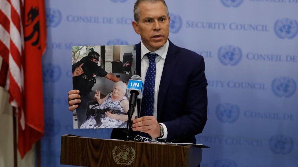 Israeli Ambassador to the United Nations, Gilad Erdan, holds up a photograph of an Israeli woman holding a Hamas machine gun