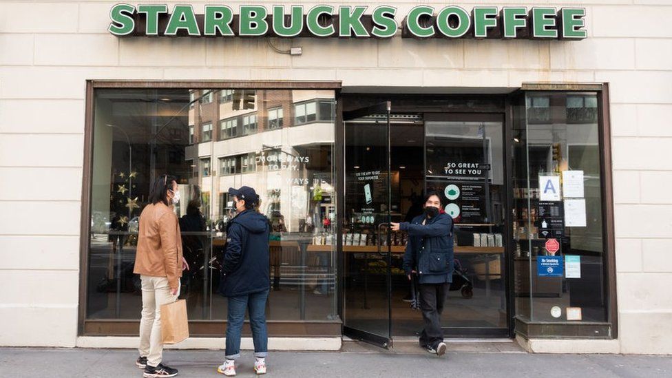 Customers outside of a Starbucks coffee shop.