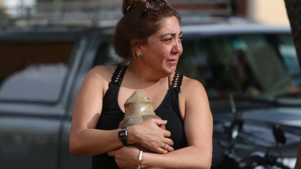 A relative carries the ashes of a victim of the Boeing 737 plane crash as she leaves a funeral parlour in Havana, Cuba, May 21, 2018.
