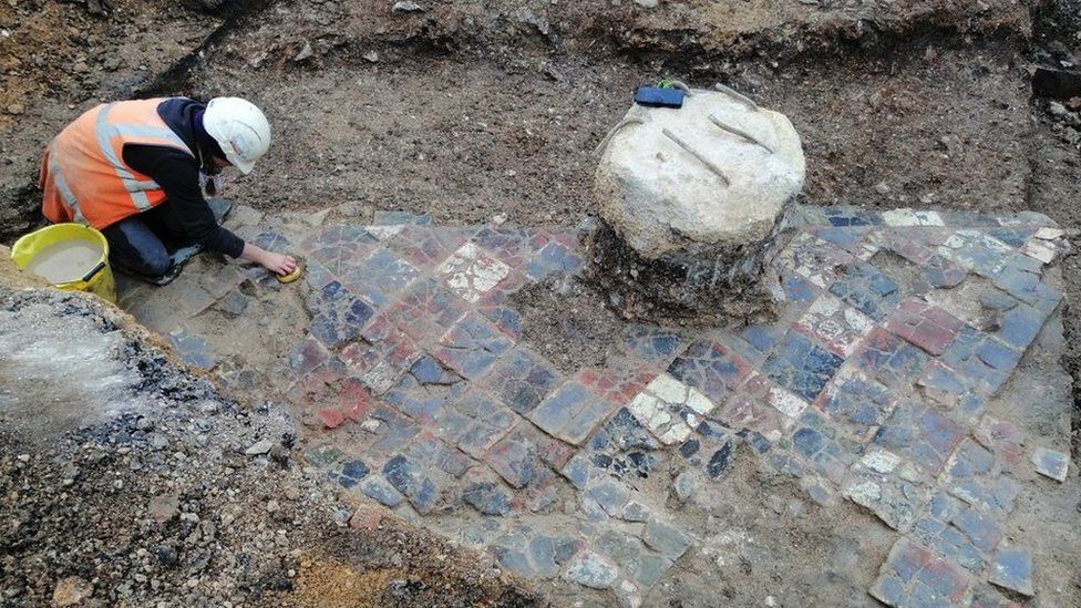 An archaeologist cleaning the tiles