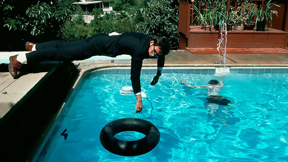 Elvis Costello lying on a swimming pool diving board, 1978