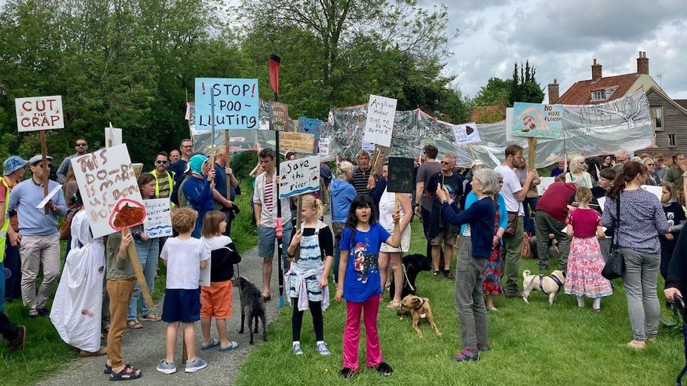 Protestors at a Procession Against Poo in Bungay, Suffolk, holding placards