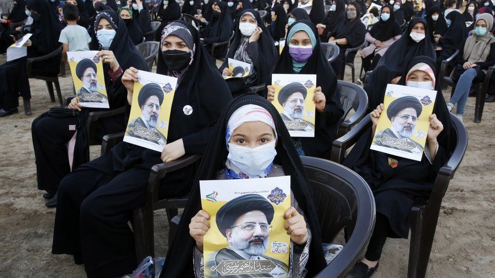 Supporters of Iranian presidential candidate Ebrahim Raisi hold pictures of him at an election rally in Eslamshahr, Iran (6 June 2021)