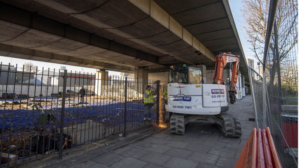 Team cut through a lock with a circular saw to allow their digger to enter site under Westway