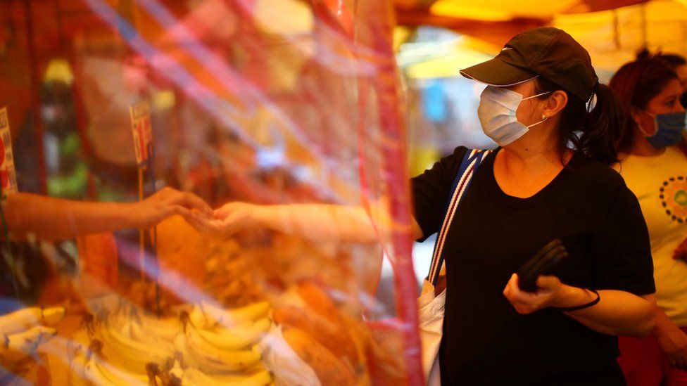 A woman buys at a local market as it reopens in Mexico City