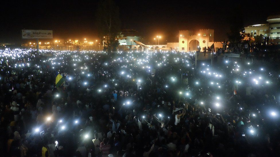 A crowd using their mobile phone lights at a sit-in at the military HQ in Khartoum, Sudan - Sunday 7 April 2019