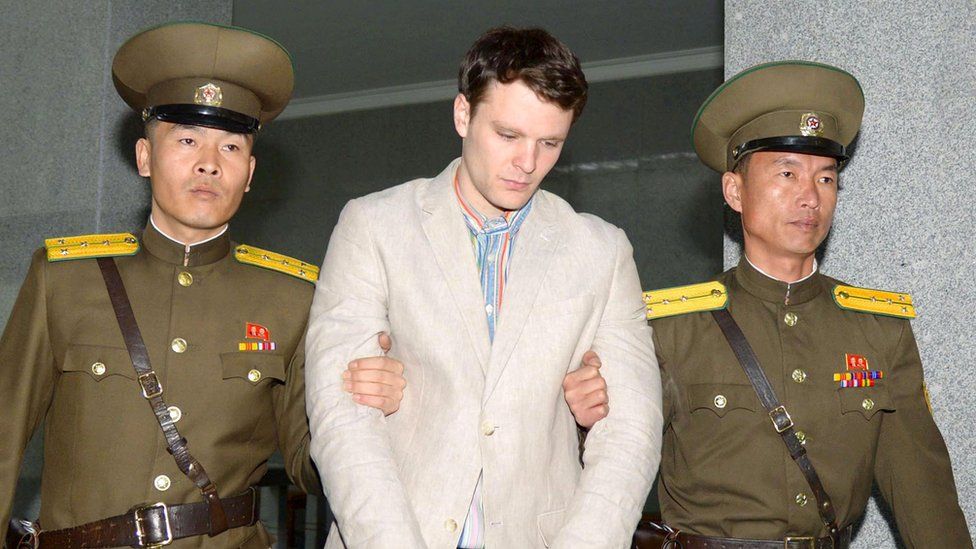 Otto Frederick Warmbier, flanked by two North Korean guards