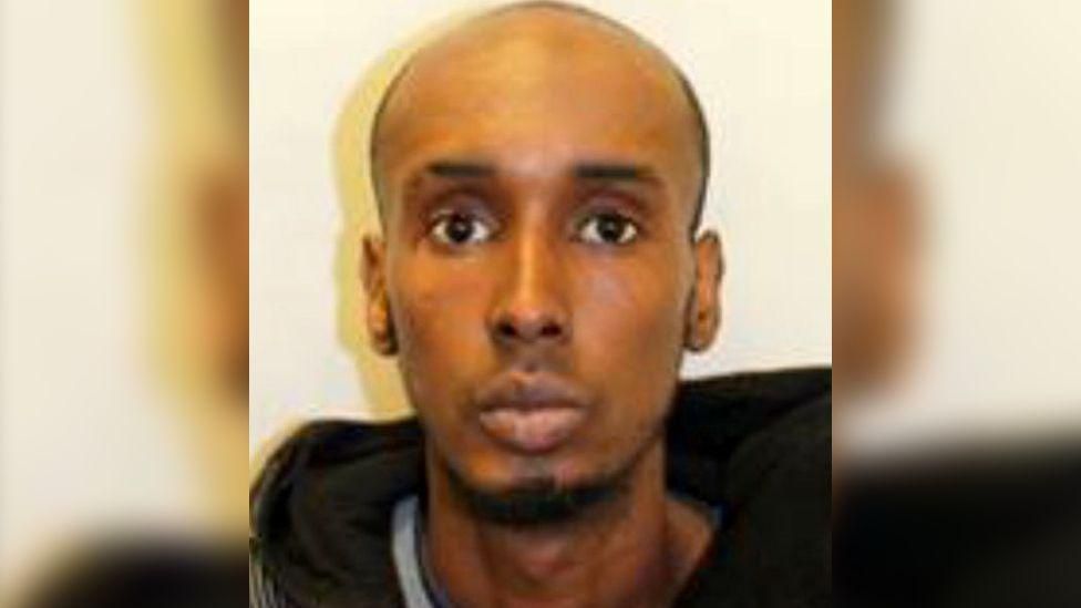 Custody image of Mohamed Nur, a bald man with a goatee wearing a black hoodie