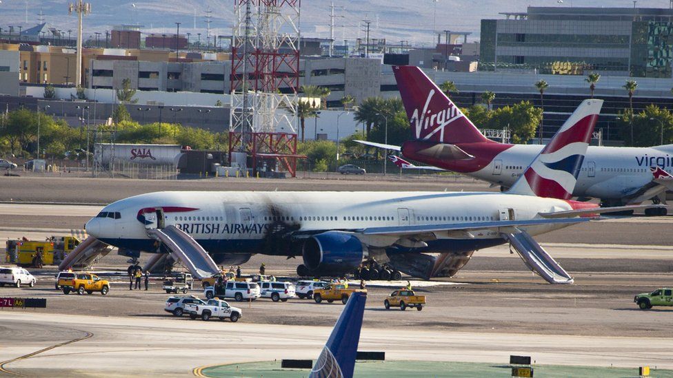 The plane stands on runway surrounded by emergency vehicles at McCarran International Airport following a fire onboard on 8 September 2015