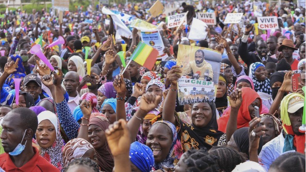 A Malian woman holds a poster with the image of Colonel Assimi Goita, the president of the National Committee for the Salvation of the People (CNSP), as she attends a mass gathering of supporters at Independence Square in Bamako on 8 September 2020.