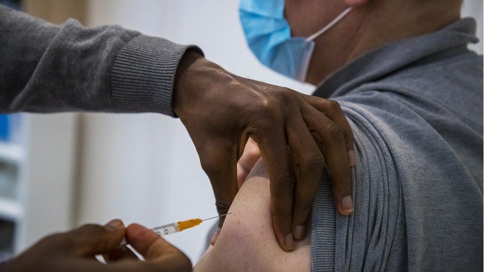 A man receives the first dose of the Oxford Astra-Zeneca COVID-19 vaccine at a private medical office, in Paris