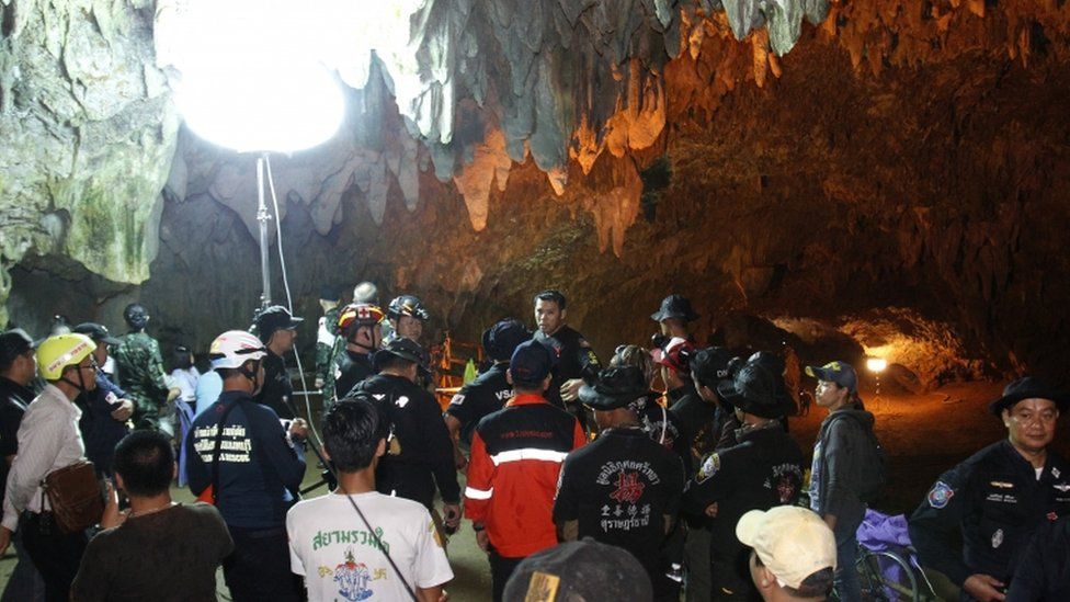 People gather in the cave system for a briefing, with special lighting equipment brought in