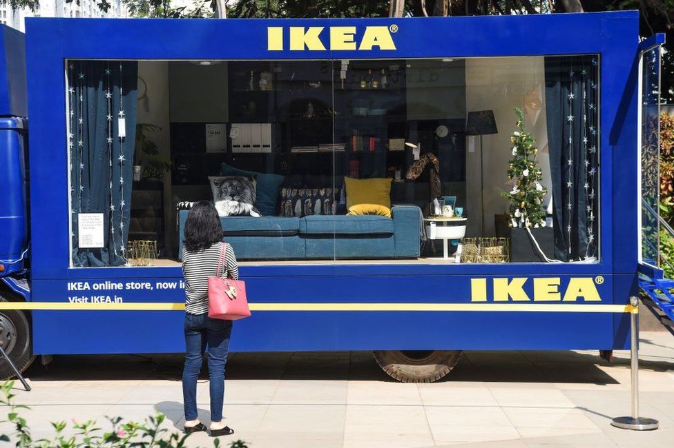 A woman watches an Ikea mobile display unit in Mumbai on November 26, 2019. - Ikea, which opened its first store in India in August 2018, is seeking to wow India's burgeoning middle class with its Nordic-cool furniture and fittings, as well as products suited to local tastes, and is aiming to open 25 outlets in the country by 2025.