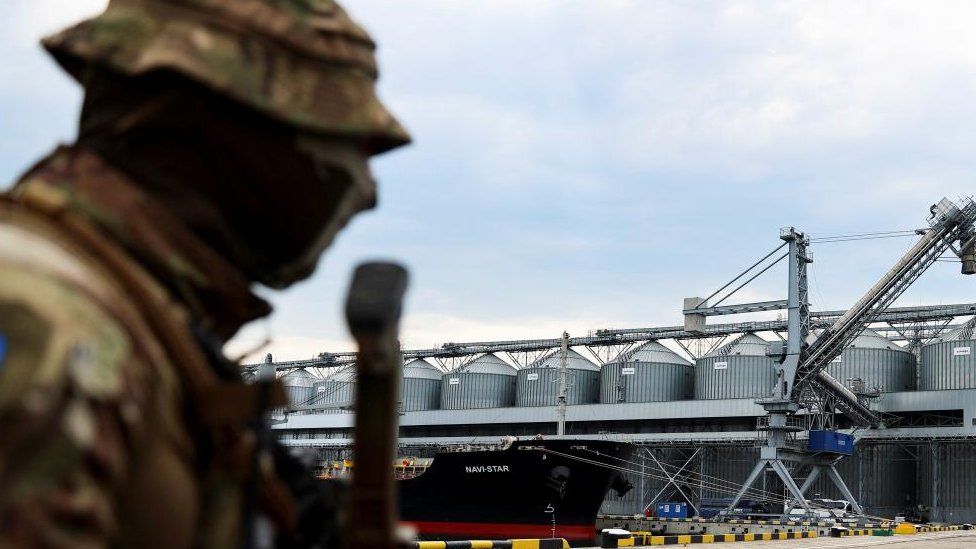 A Ukrainian serviceman stands successful  beforehand   of silos of atom  from Odesa Black Sea port, 29 July 2022