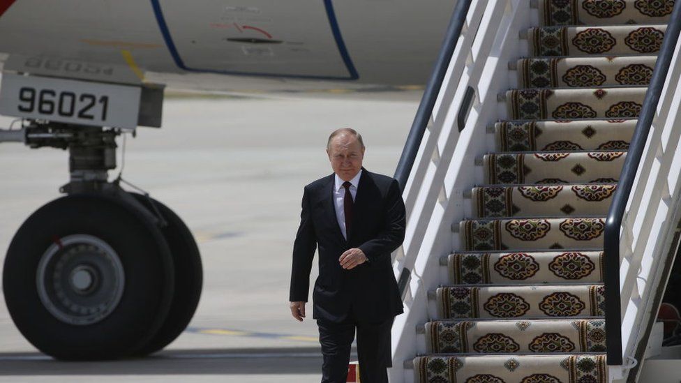 Vladimir Putin walks off a plane