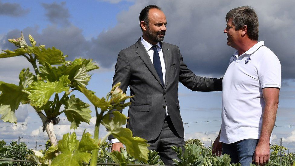 French Prime Minister Edouard Philippe (L) speaks with winegrower Christophe Charrier who manages a winery engaged in pesticide and glyphosate reduction in Val des Vignes near Angouleme, western France, on May 3, 2019,