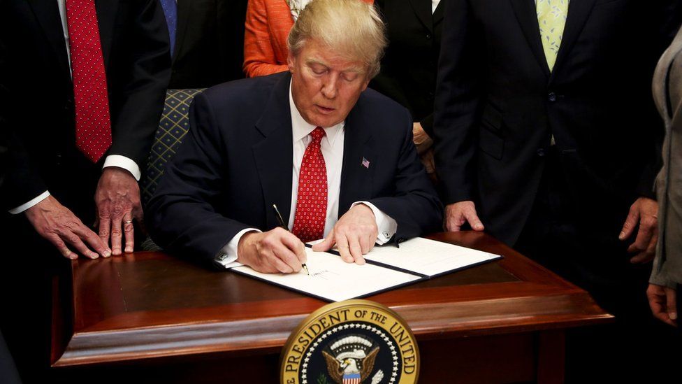 President Donald Trump signs an Executive Order to begin the roll-back Obama-era environmental regulations on 28 February 2017