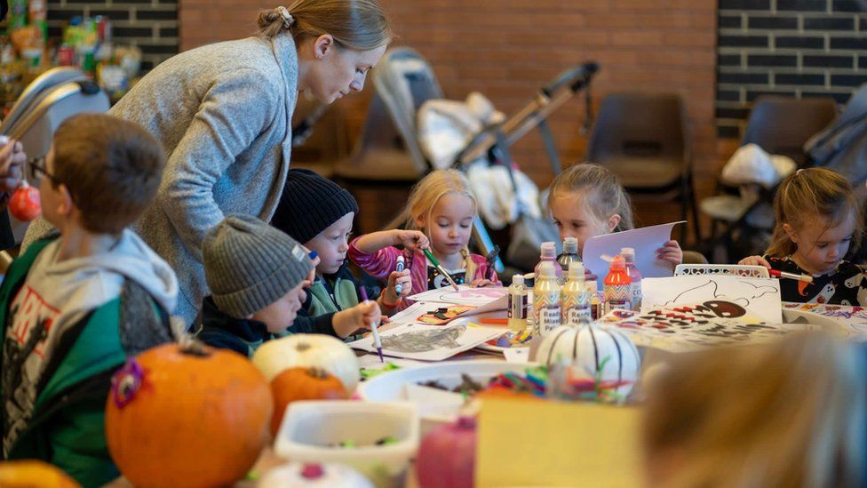 A group of five children painting Halloween pictures