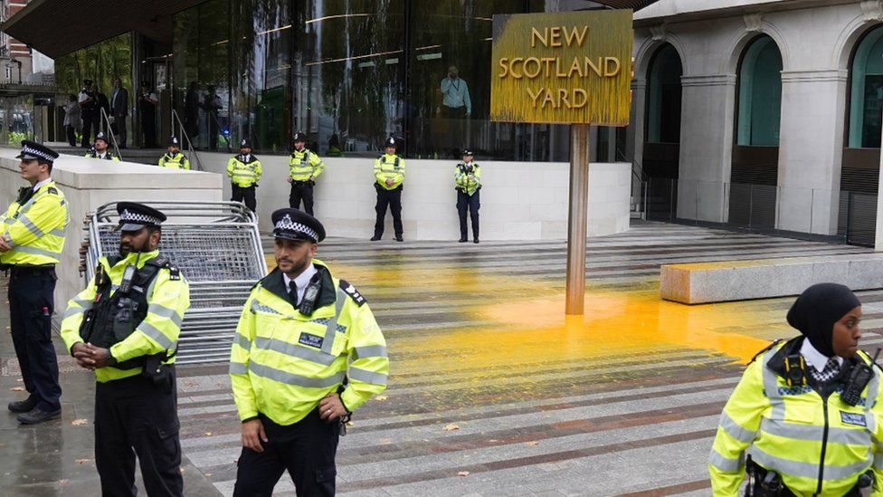 NEW SCOTLAND YARD SIGN COVERED IN YELLOW PAINT