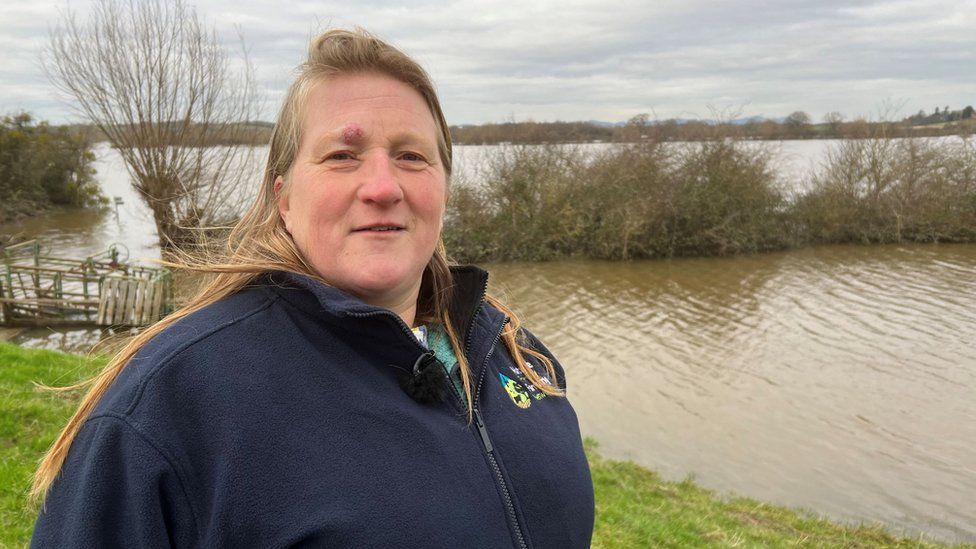 Debbie Wilkins standing in front of a flooded field