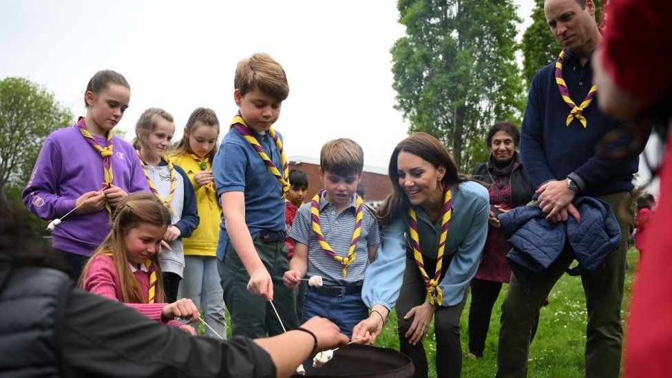 Britain's Prince William, Prince of Wales (R) looks on as (L-R) Britain's Princess Charlotte of Wales, Britain's Prince George of Wales, Britain's Prince Louis of Wales and Britain's Catherine, Princess of Wales toast marshmallows as they take part in the Big Help Out, during a visit to the 3rd Upton Scouts Hut in Slough, west of London