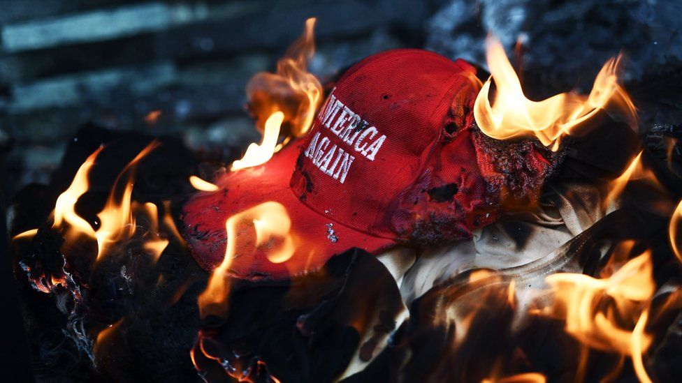 A Trump campaign hat set on fire by protesters during demonstrations in Washington