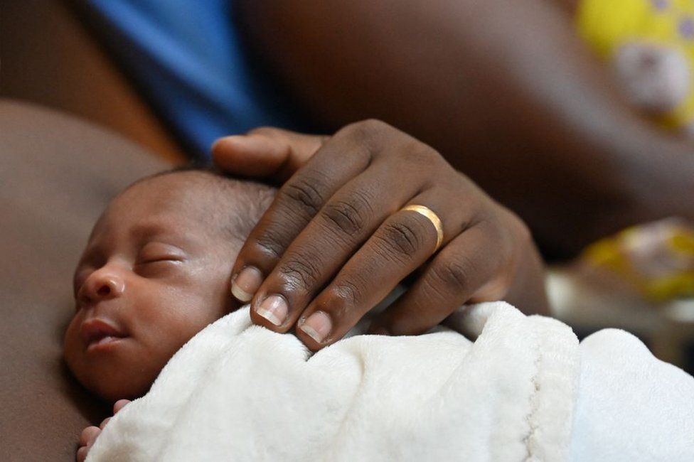 A mother holds her premature baby at the Kangaroo Mothers Unit at the University Hospital of Treichville in Abidjan on 19 June.