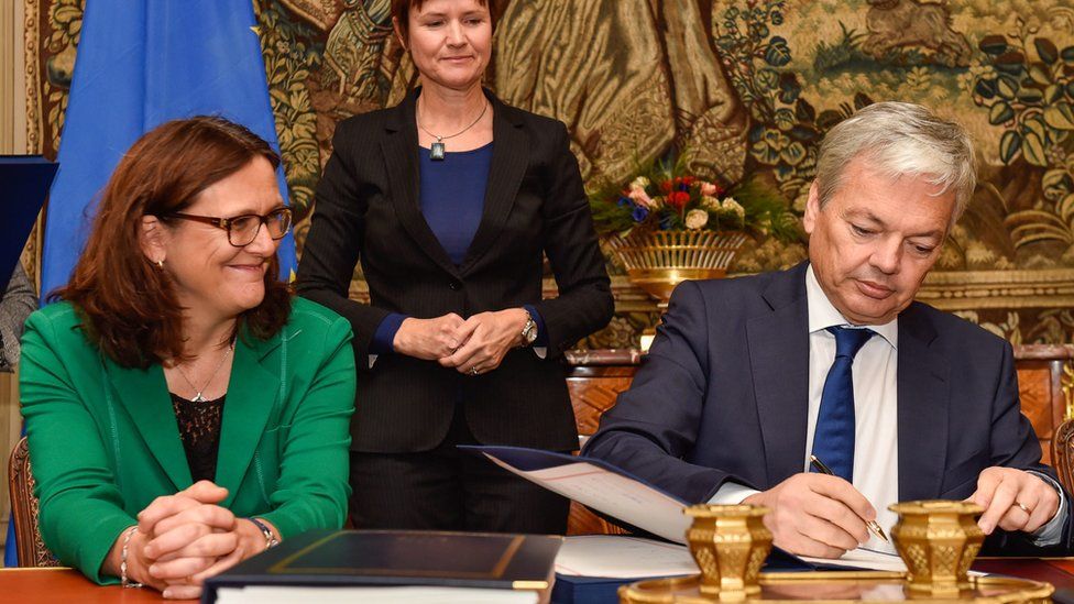 Belgian Foreign Minister Didier Reynders signs Belgian agreement on Ceta in presence of EU Trade commissioner Cecilia Malmstrom (L) - 29 October