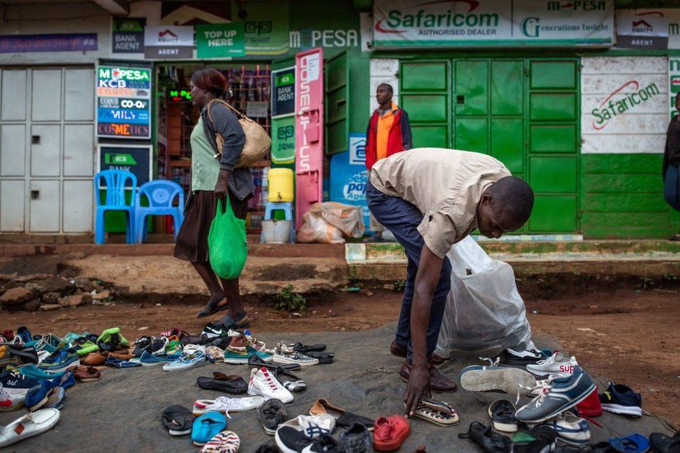 Man gathering shoes in a market