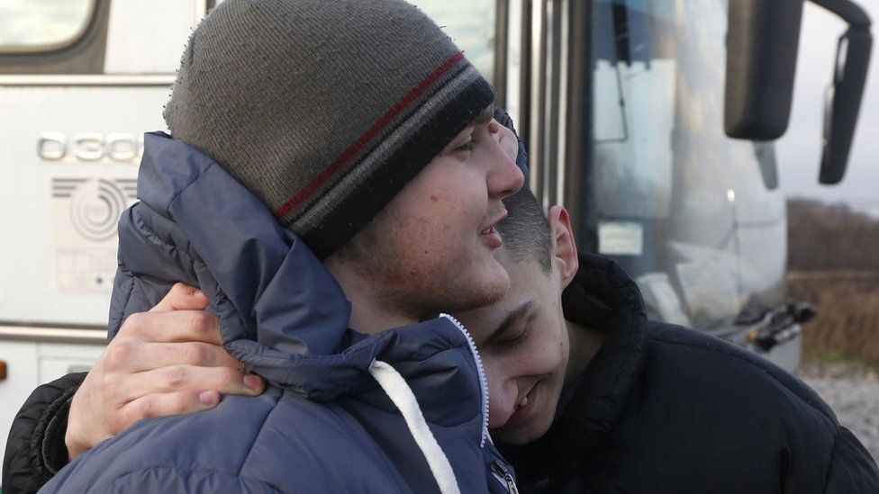 Ukrainian prisoners hug each other during a prisoner exchange in eastern Ukraine