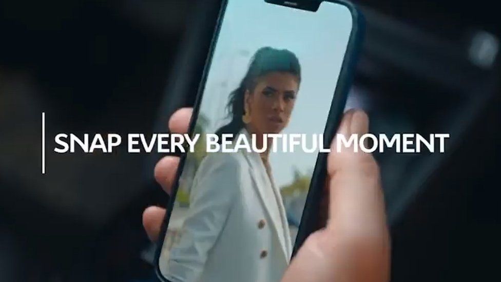Citroen C4 advert showing a photo of a woman on a mobile phone and the slogan "Snap every beautiful moment"