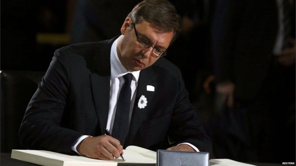 Serbian Prime Minister Aleksandar Vucic writes in the book of condolences during a ceremony marking the 20th anniversary of the Srebrenica massacre in Potocari.