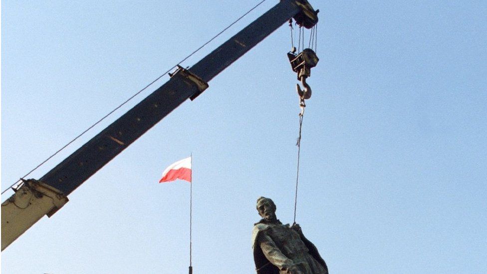 This file photo taken on 17 November 1989 in Warsaw shows people as the statue of Felix Dzerzhinsky, the founder of the first Soviet secret service, is taken down.
