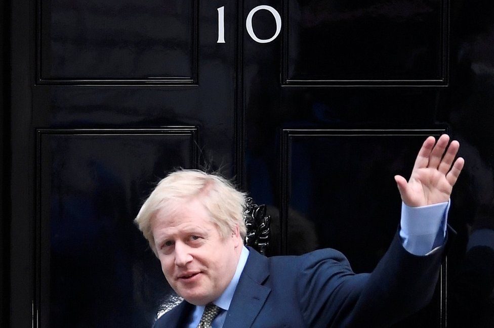 Boris Johnson waves as he arrives at Downing Street